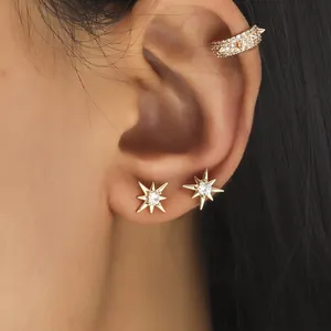 Gold star stud earrings and pavé zircon ear cuff set shown on model's ear