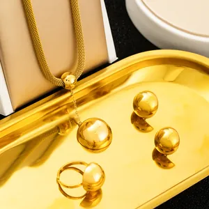 Detailed view of polished gold sphere jewelry set featuring necklace, ring and earrings