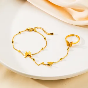 Dettaglio del bracciale anello dorato con farfalle satinate e catena con palline