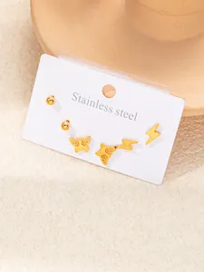 Détails d'un ensemble de boucles d'oreilles dorées en acier inoxydable avec papillon et éclair