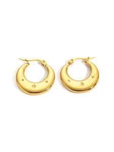 Detail of golden stainless steel hoop earrings featuring engraved star patterns and satin finish