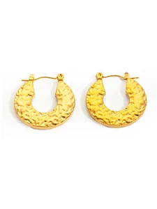 Detail of vintage golden hammered texture hoop earrings in polished stainless steel