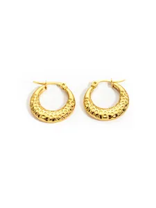 Detailed close-up of gold hoop earrings with textured honeycomb pattern in stainless steel