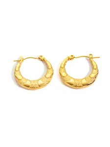 Detailed view of gold hoop earrings with textured crescent design and star patterns