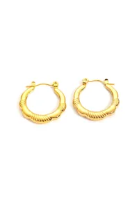 Detail of gold titanium steel earrings featuring wavy texture and snap closure design