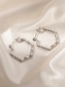 Detailed view of silver hexagonal hoop earrings with unique bamboo texture on silk