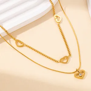 Dettaglio della collana a doppia catena dorata con cuori aperti e cristallo lucente