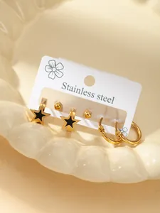 Detailansicht der goldenen Edelstahl-Creolen und schwarzen Sternstecker im Set