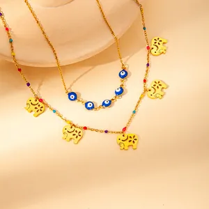 Detail of golden double-layer necklace with hollow elephants and blue evil eye beads