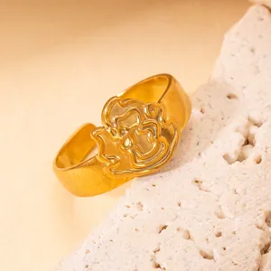 Gros plan détaillé d'une bague ouverte en acier doré avec motif logo ajouré minimaliste