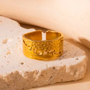 Nahaufnahme des goldenen Titanrings mit unregelmäßigen Ausschnitten und Blasenstruktur