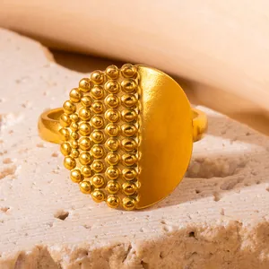 Makroaufnahme eines goldenen Titanstahlrings mit Perlenbesatz und mattierter Textur