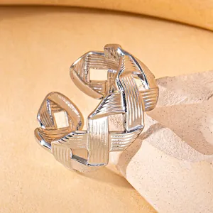 Macro shot of silver woven stainless steel adjustable ring on light textured stone