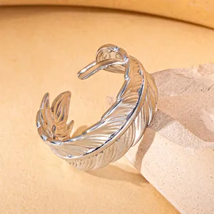 Detailed close-up of a silver-toned feather-shaped ring with an adjustable open design