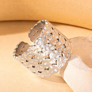 Macro detail of wide hammered texture stainless steel ring with clover cutouts