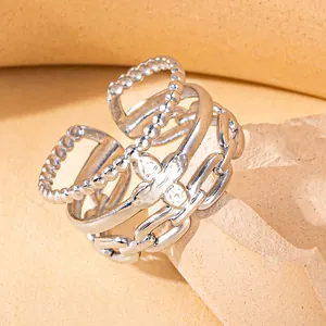 Macro detail of silver-toned multi-layer ring with braided chains and star relief design