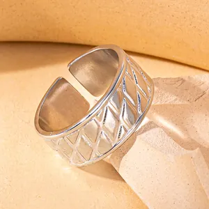 Detail of silver stainless steel open ring featuring a textured diamond pattern