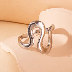 Nahaufnahme eines minimalistischen Wellenrings in Silber auf dekorativem Stein