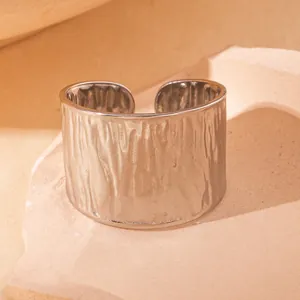 Makroansicht breiter silberner Edelstahlring mit rustikaler Hammerschlag-Oberfläche