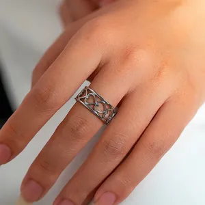 Detailopname van een roestvrijstalen hartjesring in zilver gedragen aan de vinger
