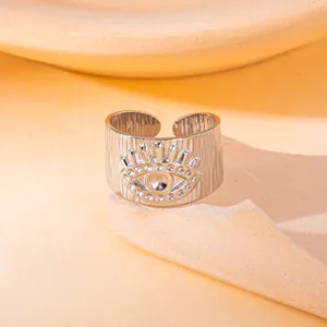 Gedetailleerde opname van een verstelbare zilveren ring van roestvrij staal met evil eye reliëf en textuur