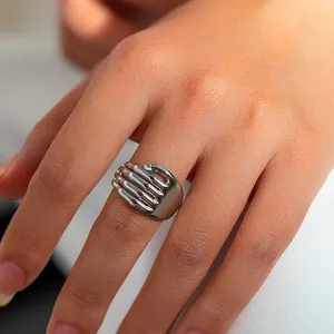 Gedetailleerde close-up van een zilveren handvormige knuffelring van gepolijst staal