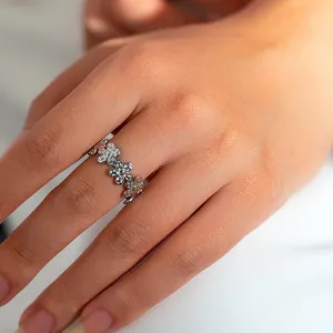 Close-up van de zilveren madeliefjesring met verfijnd bloemmotief aan de vinger