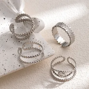 Adjustable silver stainless steel ring set with beaded texture on white ceramic plate