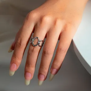 Close-up of a silver hollow chain link ring made of stainless steel on a finger