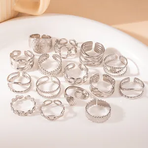 Close-up of various silver stainless steel rings with cross and heart designs in a tray