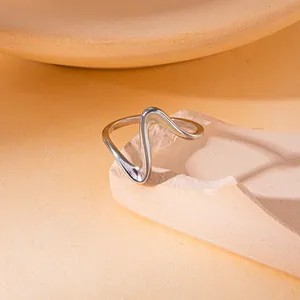 Detailopname van een zilveren golfvormige titaniumstalen ring op getextureerde rots