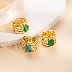 Detail of gold adjustable multi-layer rings with green turquoise and cat-eye stones