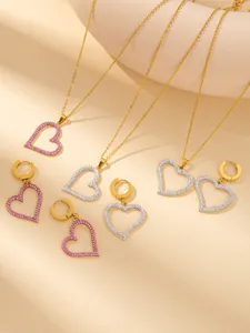 Detailed view of gold plated heart necklaces and earrings with pavé set zircon crystals