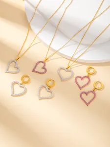 Macro detail of heart-shaped titanium steel jewelry set with white and pink pavé crystals