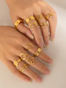 Detailaufnahme goldener stapelbarer Ringe mit Herz-, Blumen- und Schmetterlingsmustern