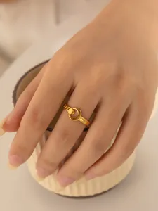 Nahaufnahme eines modernen goldenen Rings mit Sichel- und Kugel-Design am Fingermodel