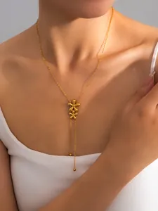 Detail of gold Y-shaped bow necklace with double flower pendants on model's neckline