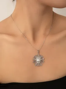 Dettaglio della collana a girasole d'argento con ciondolo di perla bianca su una modella