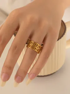 Detailansicht eines breiten Edelstahlrings in Gold mit Kettenglied-Design am Finger
