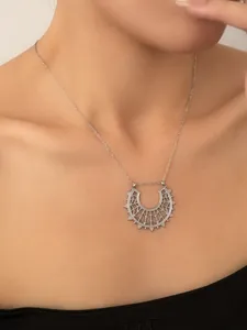 Dettaglio del ciondolo a semicerchio in argento su una sottile catena a clavicola