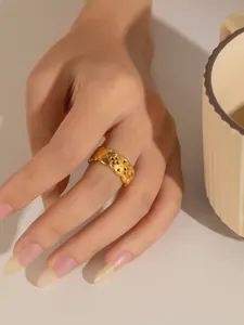 Vista detallada de un anillo de acero de titanio dorado con diseño acolchado