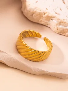 Vista de detalle del anillo croissant dorado con textura de espiral y acabado vintage