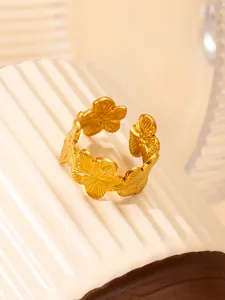 Primer plano del anillo de flores doradas con pétalos grabados en soporte texturizado