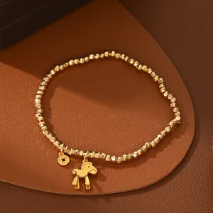Detalle macro de pulsera de cuentas doradas con colgantes de caballo y moneda en cuero
