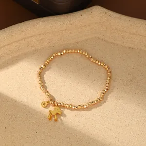 Primer plano detallado de pulsera con cuentas doradas y colgante de caballo