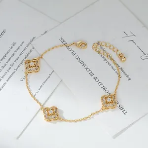 Dettaglio del bracciale a quadrifoglio dorato con zirconi e catena di chiusura regolabile