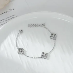 Bracciale a quadrifoglio argento con zirconi scintillanti su piatto di ceramica