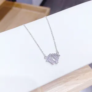 Macro shot of silver baby footprint pendant with sparkling cubic zirconia on a fine chain