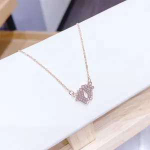 Macro detail of rose gold necklace featuring sparkling pavé crystal baby footprints