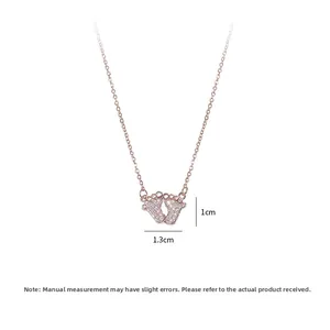 Close-up of rose gold footprint pendant with dimensions 1.3cm by 1.0cm and cubic zirconia